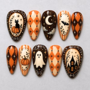May include: A set of ten press-on nails featuring Halloween-themed designs including a black cat on a pumpkin, orange and black diamond patterns, a crescent moon with clouds, a flying bat, a ghost, and a haunted house silhouette with stars.
