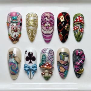 May include: A set of ten artificial nails, each uniquely designed with characters and motifs from Alice in Wonderland. Designs include the White Rabbit, Cheshire Cat, playing cards, mushrooms, and the Mad Hatter's hat, all in vibrant colors.