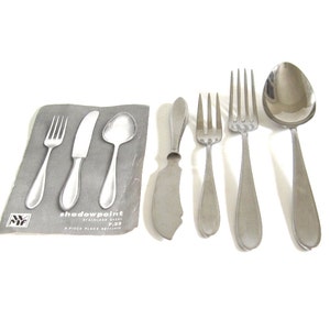 以下が含まれることがあります： シャドウポイントパターンで、ステンレス製の5点セットの食器。セットには、ナイフ、フォーク、スプーンが含まれています。