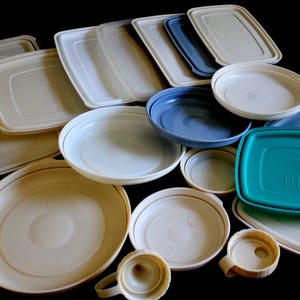 May include: A collection of various sizes and shapes of plastic storage containers. The containers are in shades of white, blue, and green.