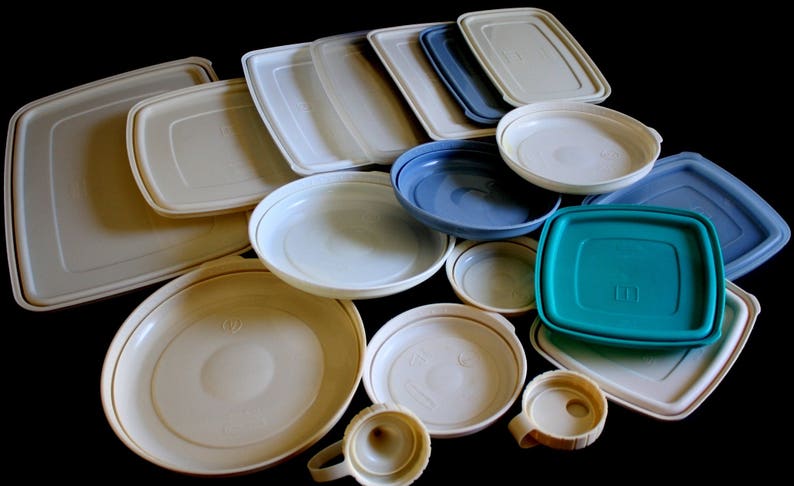 May include: A collection of various sizes and shapes of plastic storage containers. The containers are in shades of white, blue, and green.