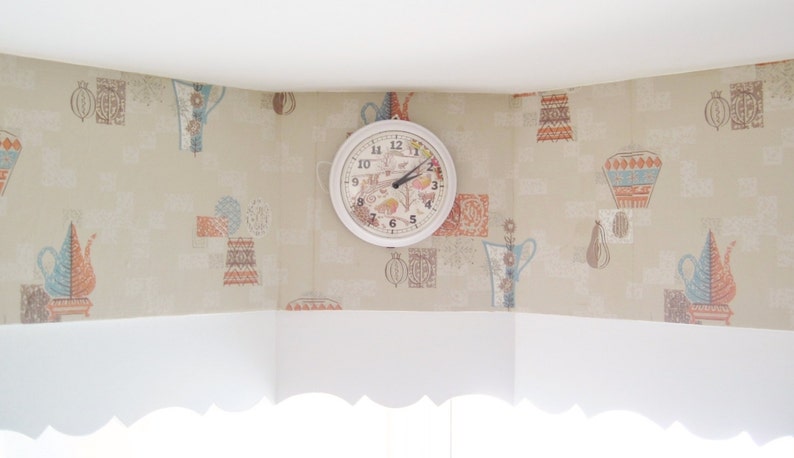 Peut inclure: Une horloge blanche avec des aiguilles noires et des chiffres romains sur un mur beige &agrave; motif floral. L'horloge a un motif floral sur le cadran.