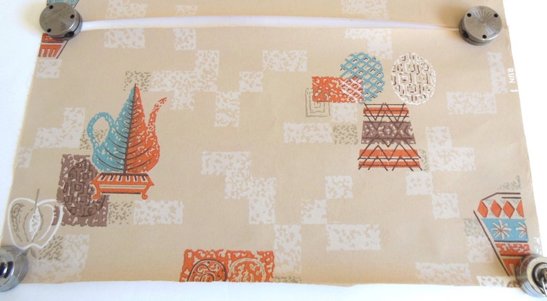 Peut inclure: Papier peint beige avec un motif g&eacute;om&eacute;trique aux accents orange, bleu et marron. Le motif comprend des th&eacute;i&egrave;res stylis&eacute;es, des cercles et des carr&eacute;s.