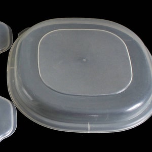 May include: Three clear plastic food storage containers with lids. The lids have a rounded edge and a small lip for easy gripping.