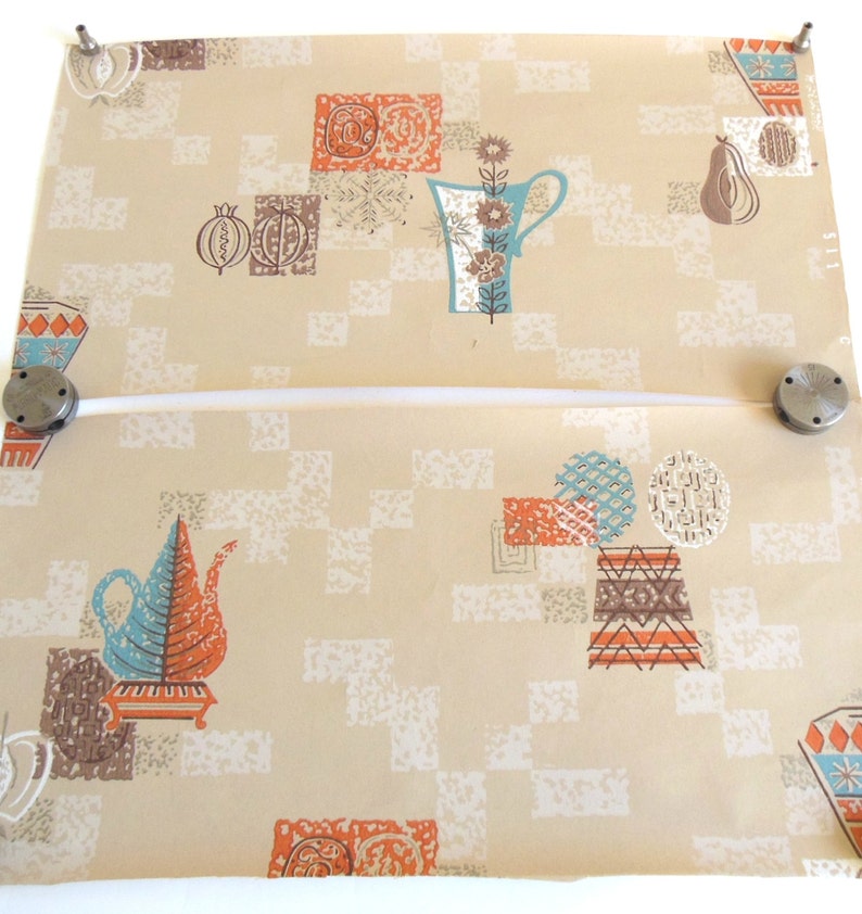 Peut inclure: Papier peint vintage avec un motif g&eacute;om&eacute;trique dans des tons de brun, orange, bleu et blanc. Le motif repr&eacute;sente des th&eacute;i&egrave;res, des tasses et des fruits stylis&eacute;s.