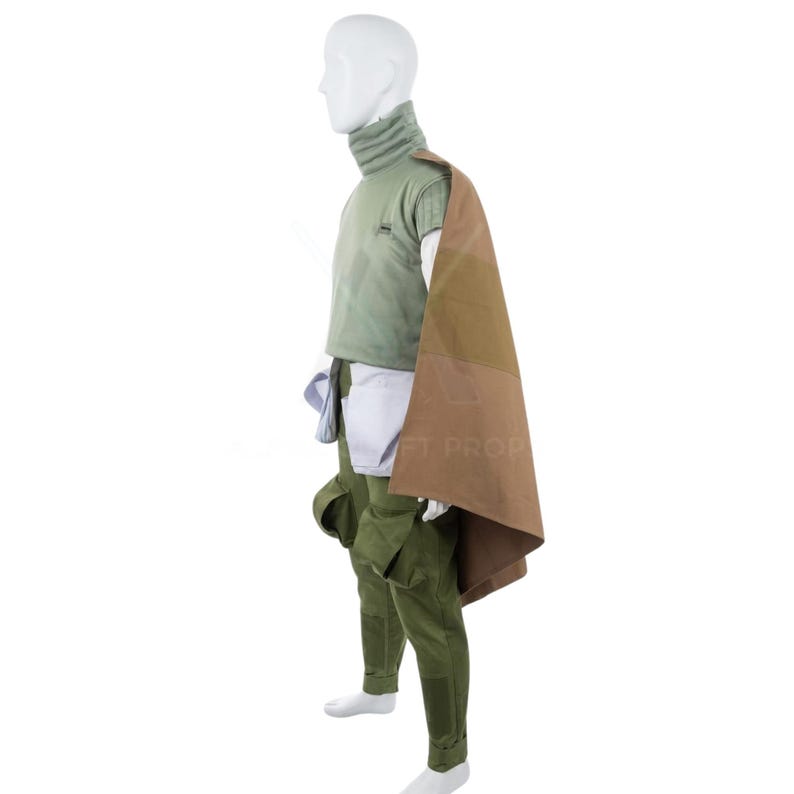 May include: A costume comprising a green turtleneck top, matching trousers, and a brown and tan cape. The outfit also features a white undershirt and a pouch. The costume is displayed on a mannequin.