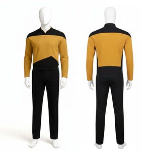 以下が含まれることがあります： マネキンに展示された、マスタードイエローとブラックのスター・トレックの制服。長袖トップスは黒い肩ヨークと胸に黒い幾何学模様が特徴です。制服には黒いパンツが含まれています。マネキンは白い背景にあります。