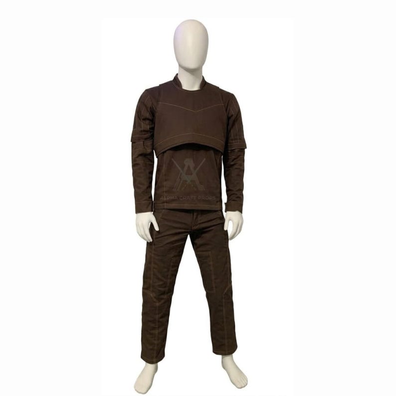 May include: A brown outfit consisting of a long-sleeved shirt, a cropped vest, and pants. The shirt has a crew neck and the pants have a straight leg. The outfit is displayed on a mannequin.
