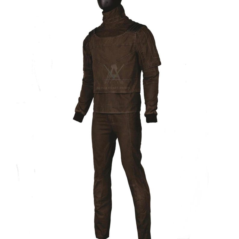 Puede incluir: Un conjunto marr&oacute;n de dos piezas con un top de cuello alto y pantalones a juego. El top tiene un dise&ntilde;o en capas con detalles en los hombros y mangas largas. Los pantalones son de corte recto. El texto "ALPHA CRAFT SHOP" es visible.