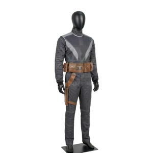 May include: A gray jumpsuit costume with a high collar and a brown utility belt. The costume has a holster on the right leg and black gloves. The mannequin is standing on a black base.