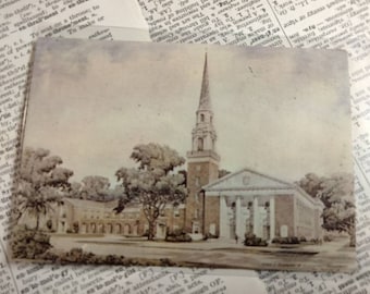 May include: A vintage postcard featuring a black and white illustration of a church with a tall steeple. The church is surrounded by trees and has a grassy lawn in front of it.