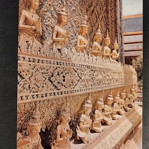 Pode incluir: Um close-up de um templo dourado com esculturas intrincadas e estátuas de pessoas. O templo é decorado com folha de ouro e tem um design muito ornamentado.