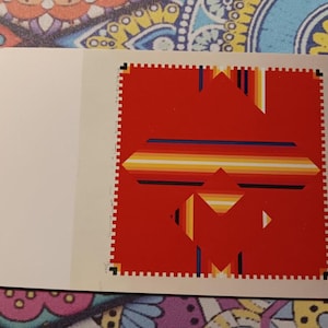 May include: A postcard featuring a red geometric design with a white border. The design includes horizontal stripes in yellow, orange, and blue. The postcard is rectangular with a blank white space on the left.