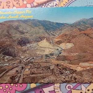 May include: Vintage postcard featuring an aerial view of the Lavender Copper Pit in Bisbee-Lowell, Arizona. The image showcases a large open-pit mine surrounded by arid mountains and a small town. The text "Lavender Copper Pit Bisbee-Lowell, Arizona" is visible.