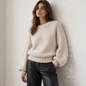 Op de afbeelding: Een crèmekleurige gebreide trui met lange mouwen, een geribbelde ronde hals, boorden en zoom. De trui heeft verlaagde schouders en volumineuze mouwen. De tekst VELMORA KNITS KNITTING PATTERNS is rechts in de afbeelding zichtbaar.