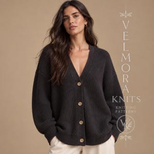 May include: A dark charcoal grey ribbed knit cardigan featuring a deep V-neckline, long sleeves, and four light-coloured buttons down the front. The text VELMORA KNITS KNITTING PATTERNS is visible on the right side of the image.