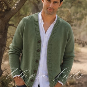 Può includere: Un cardigan in maglia color verde salvia con scollo a V, maniche lunghe e chiusura frontale con bottoni. Il capo è indossato sopra una camicia bianca con colletto. Il cardigan presenta una texture a coste lungo l'abbottonatura e i polsini.