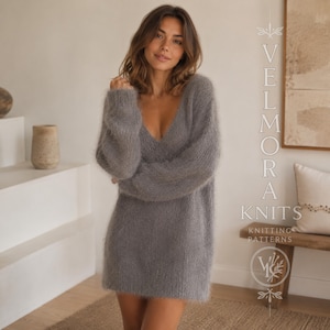 Puede incluir: Un suéter de manga larga gris carbón, de textura difusa y con un escote en V profundo. La prenda presenta una textura suave y cepillada con un corte holgado. El texto "VELMORA KNITS" y "KNITTING PATTERNS" es visible a la derecha.