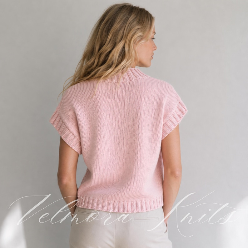 Puede incluir: Un chaleco de punto rosa claro con cuello alto acanalado, sisas acanaladas y dobladillo acanalado. La prenda est&aacute; confeccionada con un punto de jersey liso y se lleva sobre pantalones de color claro.