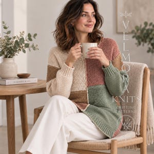 May include: A long-sleeve colour-blocked knit jumper featuring a patchwork design in shades of cream, brown, dusty rose, and sage green. The jumper has a ribbed crew neckline and ribbed cuffs. Text on the right reads VELMORA KNITS.