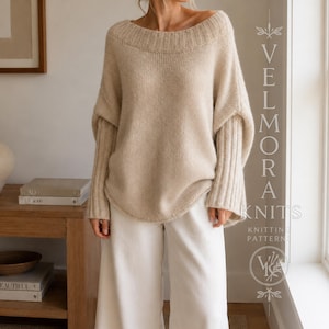 Può includere: Un maglione beige a maniche lunghe con un ampio scollo a coste e polsini a coste, indossato con pantaloni bianchi. L'immagine include il testo VELMORA KNITS KNITTING PATTERN con un logo circolare raffigurante un'icona di filo e ago.