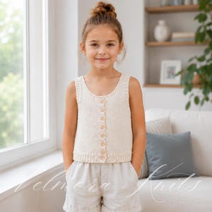 May include: A sleeveless cream-coloured knit tank top featuring a vertical row of eight small wooden buttons down the centre front, a ribbed scoop neckline, and a ribbed hemline, paired with light beige linen shorts with a cuffed leg design.