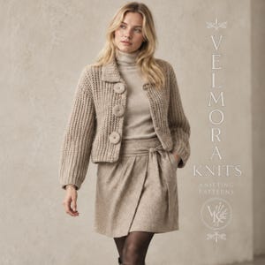 May include: A beige chunky knit cardigan with three large circular buttons, worn over a matching turtleneck sweater and a wrap-style skirt. The text VELMORA KNITS KNITTING PATTERNS is visible on the right side of the image in a vertical layout.