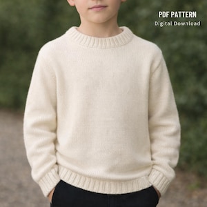 May include: Cream-colored knit sweater with a crew neck and ribbed cuffs and hem. The sweater is shown on a person. The text "PDF PATTERN Digital Download" is in the upper right corner.