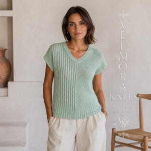 May include: A light sage green short-sleeved knit top with a V-neckline, featuring a vertical ribbed texture on one side and a plain knit texture on the other, paired with light-coloured trousers. The text VELMORA KNITS KNITTING PATTERNS is visible.