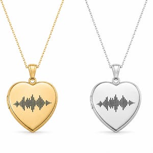 May include: Two heart-shaped locket necklaces. One is gold-toned, the other silver-toned. Each pendant features a black sound wave design. Both necklaces have delicate chains.