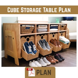 May include: A wooden cube storage table plan with woven baskets and cubbies. The table has multiple compartments for storage, including shoes and folded clothes. The text "CUBE STORAGE TABLE PLAN" is at the top. A PDF plan is available.