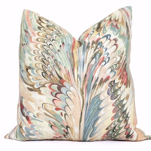 May include: A square throw pillow featuring a marbled pattern with swirling, feather-like designs in shades of muted green, soft pink, deep red, and dark brown against a cream-colored background, creating a complex, multi-layered visual texture.