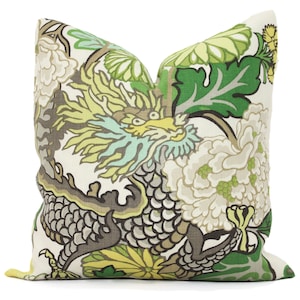 May include: A green, yellow, and gray throw pillow with a dragon and floral pattern.