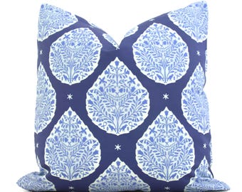 May include: A decorative pillow with a navy blue background and a repeating pattern of light blue and white floral teardrop shapes. The pillow has a soft, textured appearance and is designed for home decor.