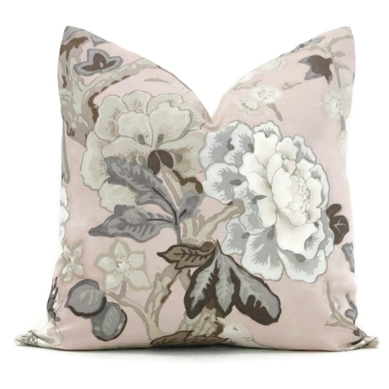 May include: A pink pillow with a floral pattern in shades of gray and brown. The flowers are large and have a delicate, feminine look.