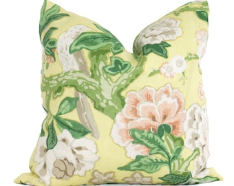 May include: A yellow pillow with a floral pattern featuring pink, white, and green flowers and leaves. The pillow has a bird design on the left side.