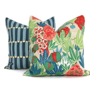 May include: Two decorative throw pillows, one with a blue and yellow striped pattern and the other with a floral pattern featuring red, green, and blue flowers on a beige background.