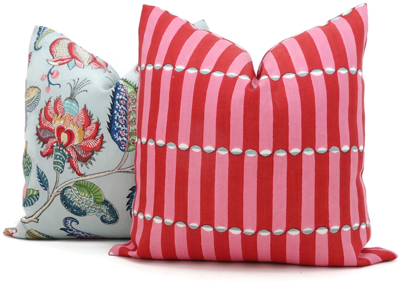 May include: Two decorative throw pillows, one with a blue background and a floral pattern, and the other with a pink and red striped pattern.