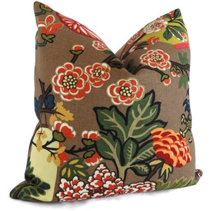 May include: A brown pillow with a floral pattern. The flowers are red, orange, yellow, and green. The pillow is made of a soft, textured fabric.