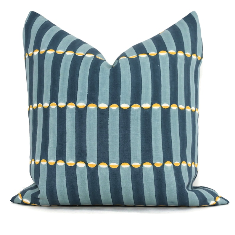 May include: A blue and yellow striped throw pillow with a geometric pattern. The pillow is made of a soft, comfortable fabric and is perfect for adding a touch of style to any room.