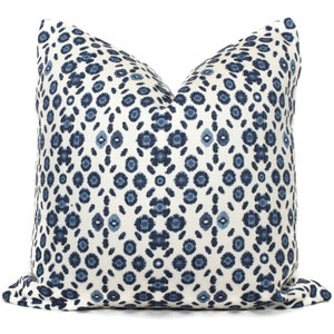 May include: A white throw pillow with a blue and navy blue geometric pattern. The pattern is a repeating design of small circles and ovals.