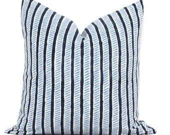 May include: A square pillow with a blue and white striped pattern. The stripes are vertical and alternate between a light blue and a darker navy blue. The pillow is made of a soft fabric and has a textured appearance.