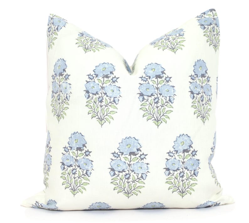 K&ouml;nnte beinhalten: Ein wei&szlig;es Kissen mit einem blauen und gr&uuml;nen Blumenmuster. Das Kissen ist aus einem weichen, bequemen Stoff gefertigt und perfekt, um jedem Raum einen Hauch von Eleganz zu verleihen.