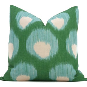 May include: Green throw pillow with a blue and white ikat pattern.
