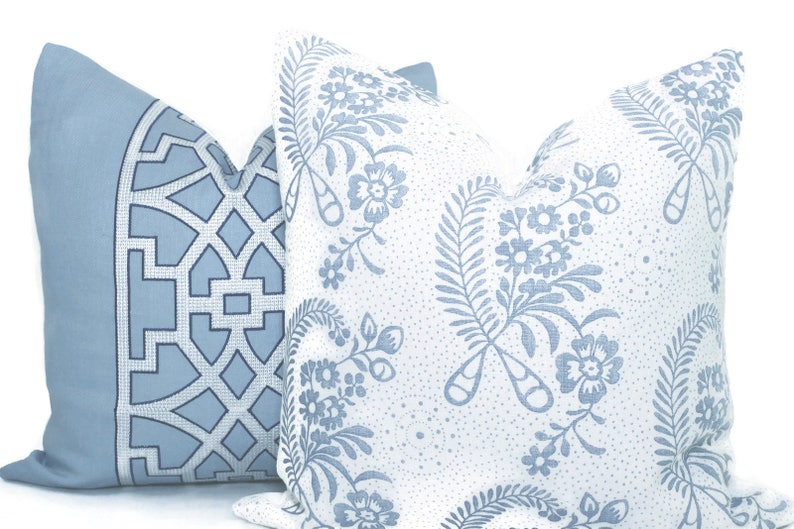 May include: Two decorative throw pillows with blue and white patterns. One pillow has a geometric design, while the other has a floral pattern.
