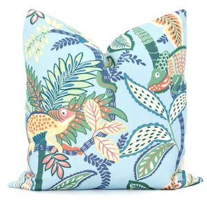 May include: A blue pillow with a colorful pattern of chameleons, leaves, and vines. The pattern is in shades of green, yellow, orange, and blue.