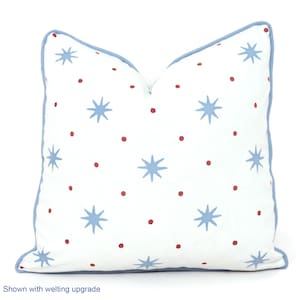 May include: White throw pillow with a blue and red star pattern. The pillow has a blue border and the text "Shown with welting upgrade" is at the bottom of the image.