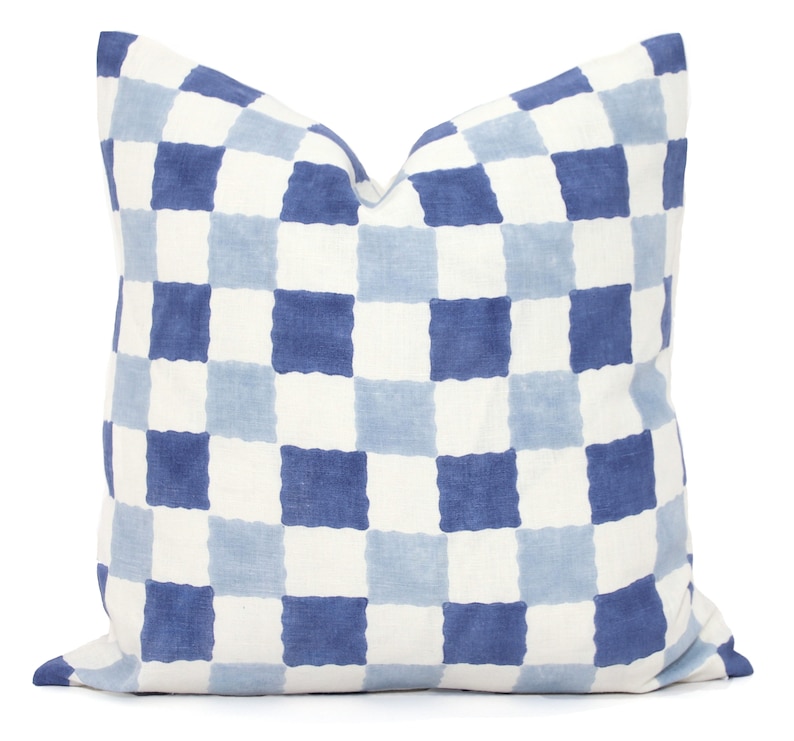 Puede incluir: Una almohada de tiro a cuadros azules y blancos con una tela suave y texturizada.