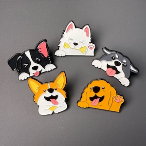 Puede incluir: Colección de cinco pines con temática de perros. Cada pin presenta una raza de perro diferente en un estilo de dibujos animados, con varios colores como negro, blanco, naranja y amarillo. Los perros se representan con expresiones felices, algunos sosteniendo huesos o saludando.