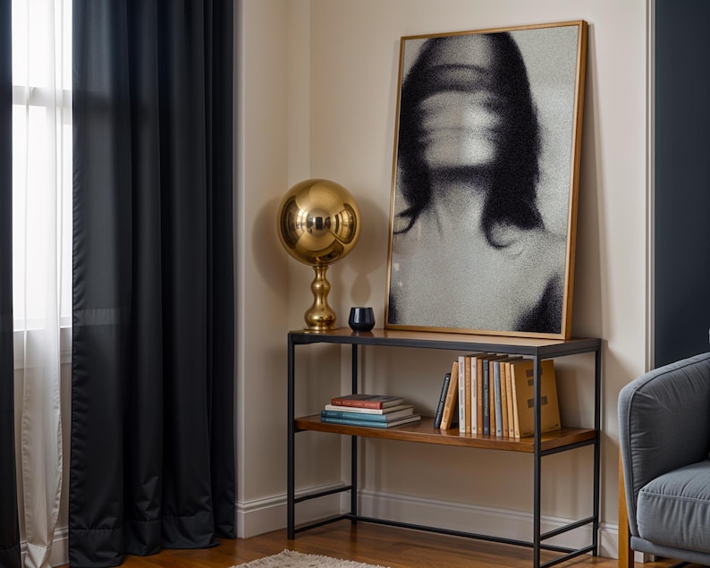 Puede incluir: Una escena de sal&oacute;n moderno con un retrato en blanco y negro con marco dorado, una l&aacute;mpara esf&eacute;rica dorada y una estanter&iacute;a de metal negro y madera con libros. Cortinas negras enmarcan una ventana.